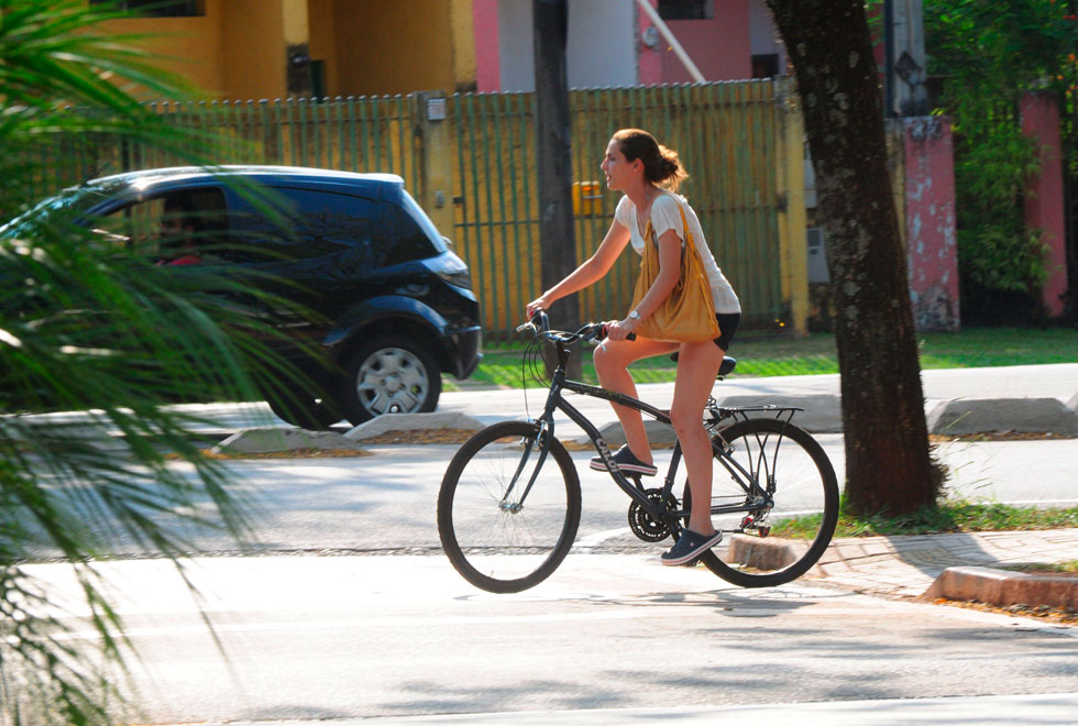 foto mostra garota em uma bicicleta andando em uma ciclovia