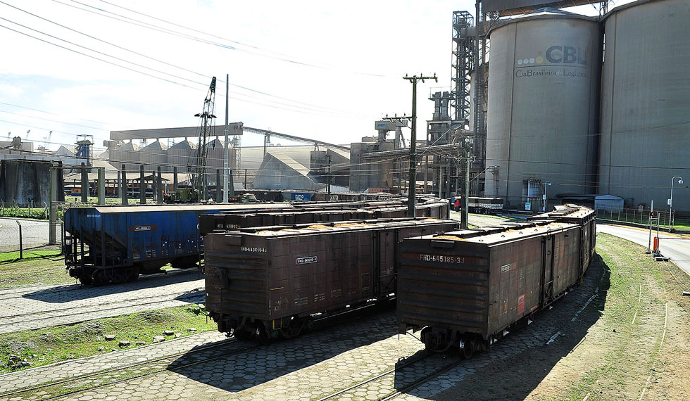 foto mostra vagões de carga em trilhos próximos a silos que armazenam grãos