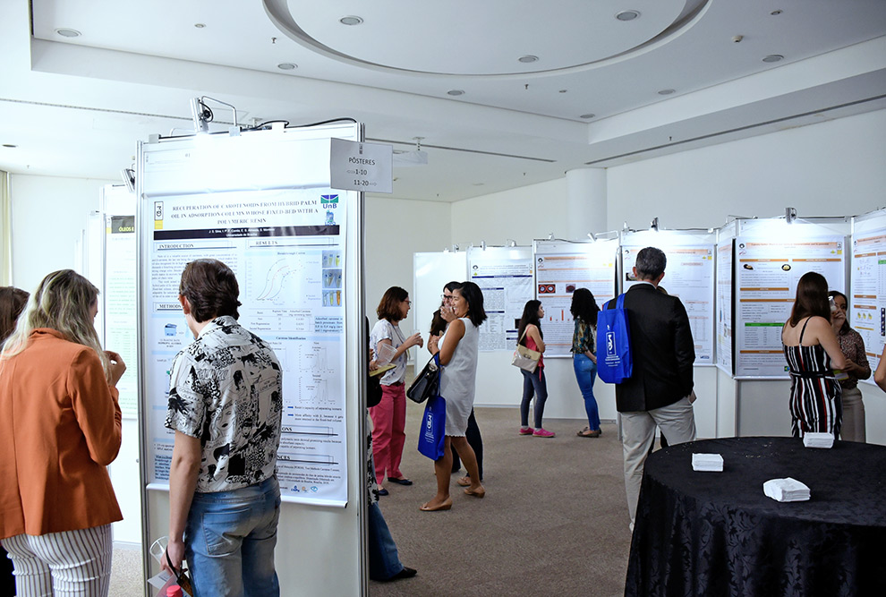 Público de evento olhando exposição de posteres de pesquisas