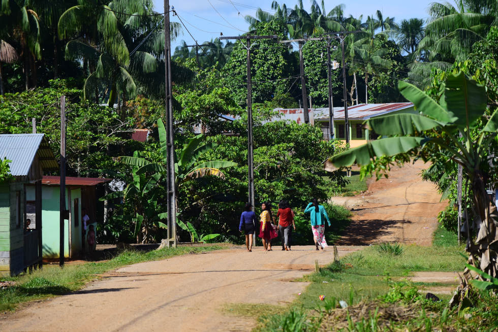audiodescrição: fotografia colorida de cenário na aldeia umariaçu II, em tabatinga, no amazonas. nela, crianças estão caminhando de costas em rua de terra