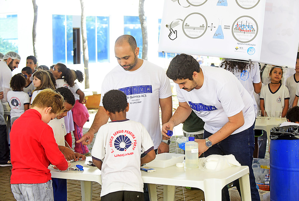 professores e crianças realizando experimento 