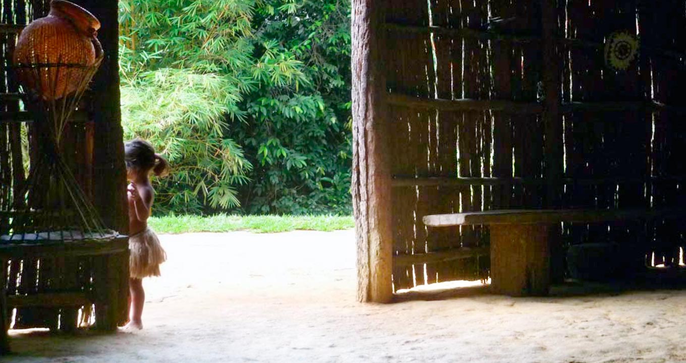 Criança indígena na porta de entrada de uma oca no Tupé, onde são exibidas as apresentações de dança | Foto: Maria Teresa Manfredo