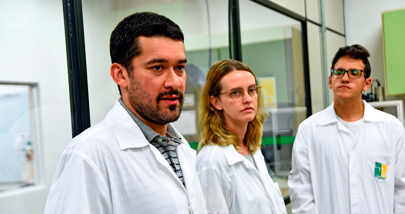 Pesquisadores investigam causa da esquizofrenia Pesquisadores aparecem no laboratório ao lado do professor Daniel