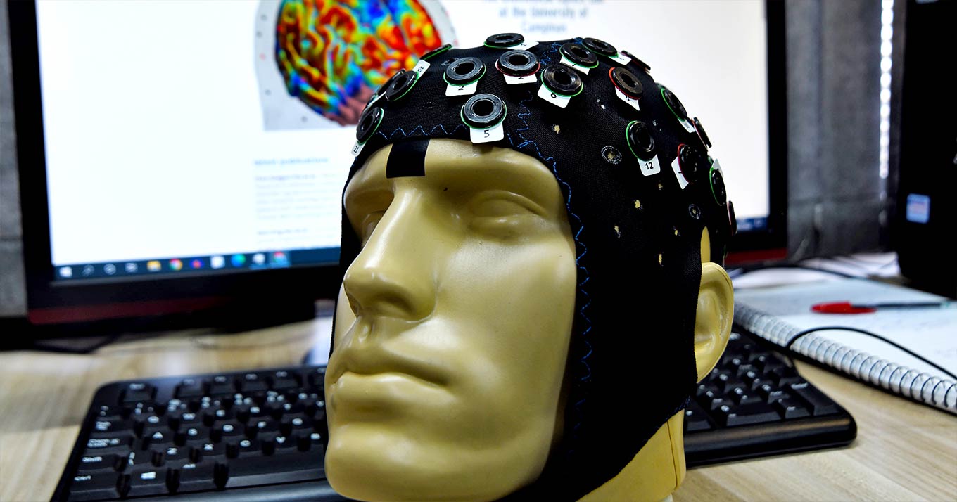 foto mostra cabeça de manequim vestindo uma touca de eletroencefalografia