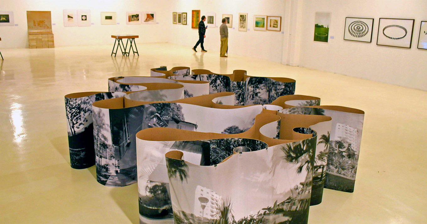 A paisagem é o recorte temático da exposição que combina peças do acervo do MAV e trabalhos de oito artistas convidados Fotografia de uma das obras da exposição que fica no chão e tem formato de uma superfície em espiral com fotos impressas e em preto e branco