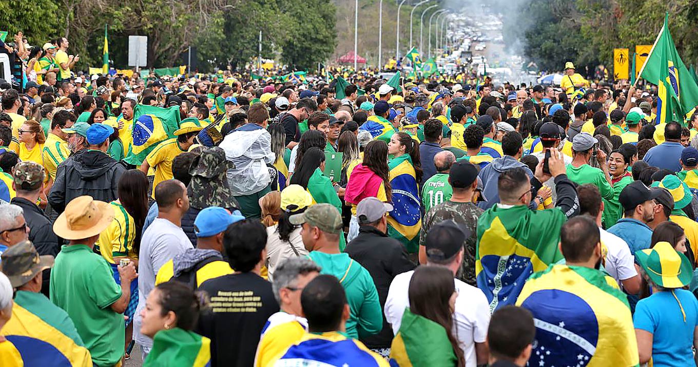 Em entrevista, pesquisador André Kaysel analisa a persistência do discurso anticomunista o discurso anticomunista Foto de manifestantes em um espaço aberto. Eles usam camisetas nas cores verde e amarelo e seguram bandeiras do Brasil.