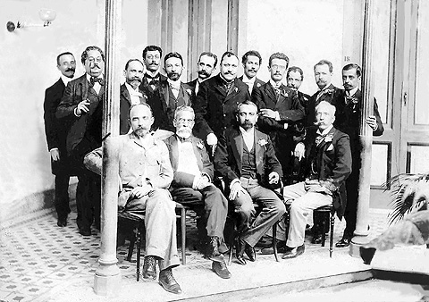 Encontro de escritores e artisas em 1901: em pé, da esq. para a dir., Rodolfo Amoedo, Artur Azevedo, Inglês de Sousa, Olavo Bilac, José Veríssimo, Sousa bandeira, Filinto de Almeida Guimarães Passos, Valentim Magalhães, Rodolfo Bernardelli, Rodrigo Octavio, Heitor Peixoto; sentados: João Ribeiro, Machado de Assis, Lúcio de Mendonça e Silva Ramos (Fotos: Academia Brasileira de Letras/Reprodução)