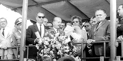 Entre Abreu Sodré (esq.) e o presidente Castello Branco (dir.), Zeferino  lê seu discurso de lançamentp da pedra fundamental, em 5 de outubro de 1966